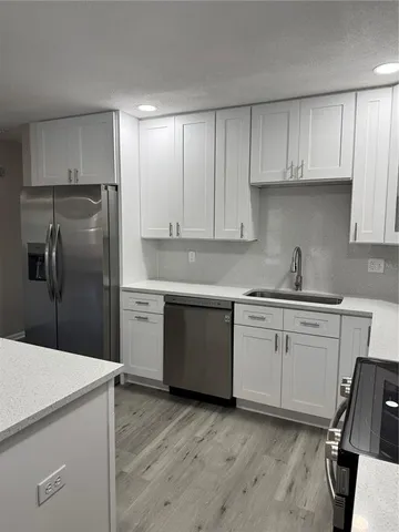 a kitchen with a sink a stove and cabinets