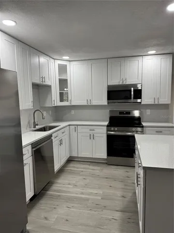 a kitchen with kitchen island a counter top space a sink and appliances