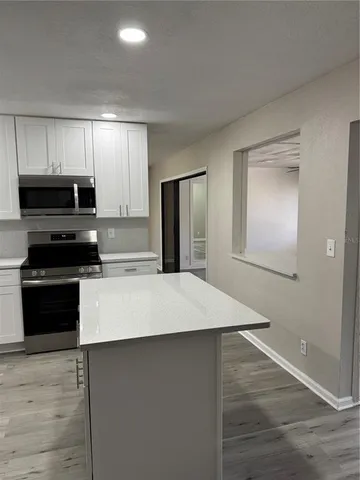 an empty room with wooden floor and a window