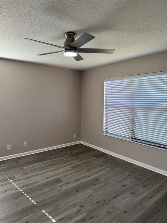 4550 Ewell Road Lakeland, FL 33811 - Photo 21 of 49 a view of an empty room with wooden floor and a window