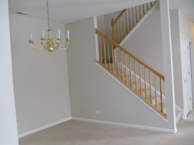 2977 Falling Waters Lane, Unit 2977 Lindenhurst, IL 60046 - Photo 4 of 25 a view of staircase with railing and pendant lights