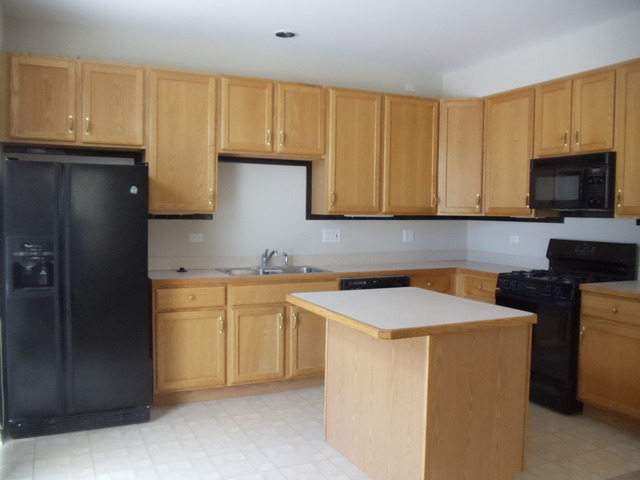 2977 Falling Waters Lane, Unit 2977 Lindenhurst, IL 60046 - Photo 5 of 25 a kitchen with stainless steel appliances granite countertop a sink stove and refrigerator