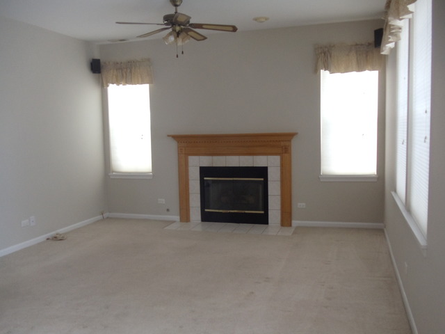 2977 Falling Waters Lane, Unit 2977 Lindenhurst, IL 60046 - Photo 7 of 25 an empty room with windows and fireplace