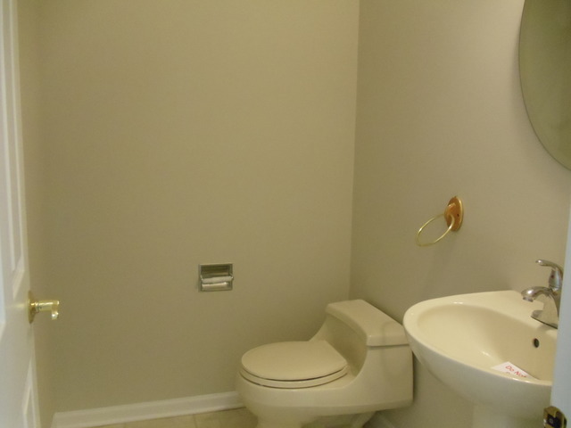 2977 Falling Waters Lane, Unit 2977 Lindenhurst, IL 60046 - Photo 9 of 25 a white toilet sitting next to a bathroom sink