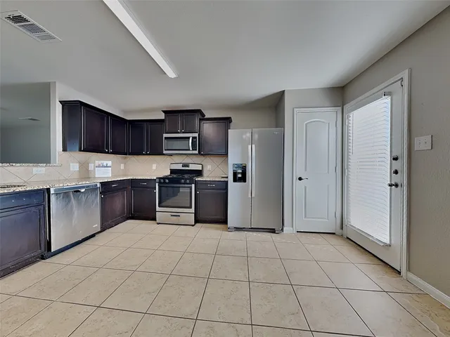 a kitchen with granite countertop a refrigerator and a sink