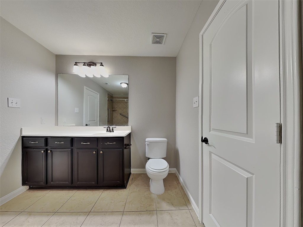 1525 Treeta Trail Kyle, TX 78640 - Photo 8 of 16 a spacious bathroom with a toilet a sink and mirror