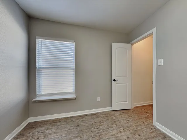a view of an empty room with window and closet area