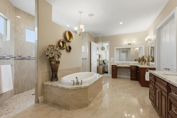 a spacious bathroom with a granite countertop sink a large mirror and a bathtub