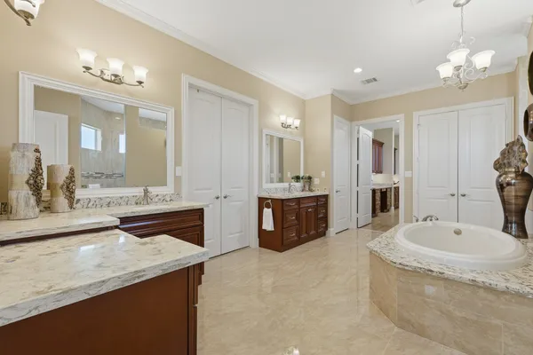 a utility room with granite countertop a sink a washer and dryer with wooden cabinets