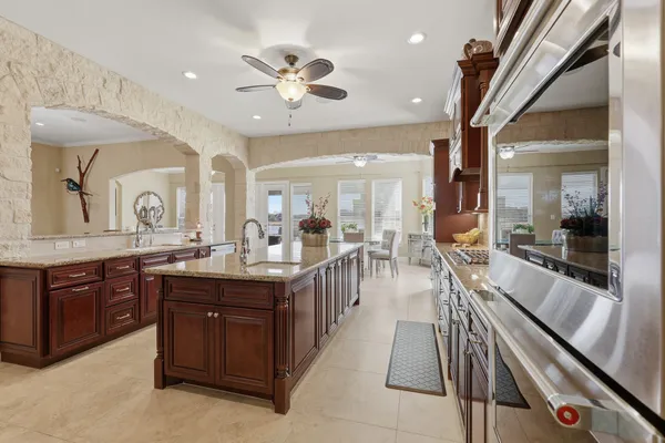 a kitchen with stainless steel appliances granite countertop a stove refrigerator a sink and dishwasher with wooden cabinets