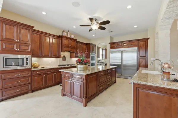 a dining hall with stainless steel appliances granite countertop a stove and a sink