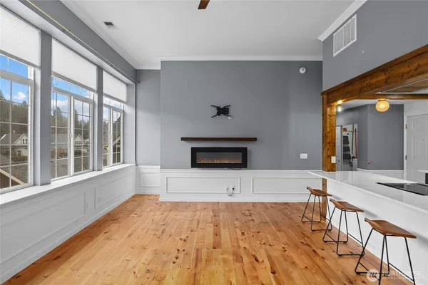a view of empty room with wooden floor and fan