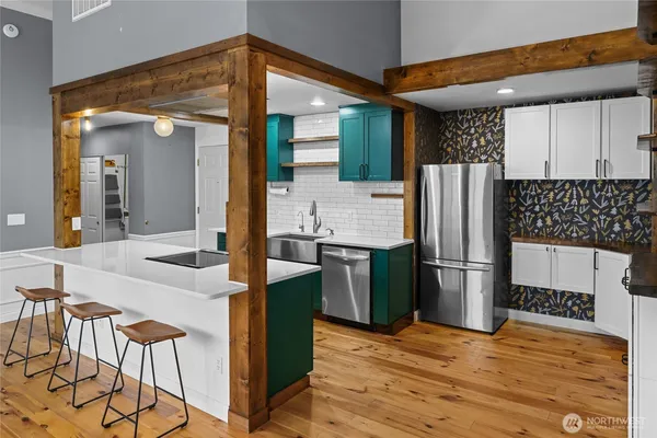 a kitchen with stainless steel appliances kitchen island granite countertop a refrigerator a stove top oven and a sink