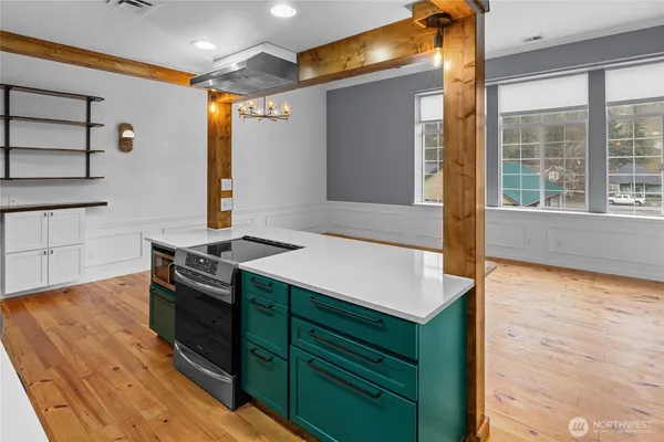 a kitchen with a stove and a wooden floor