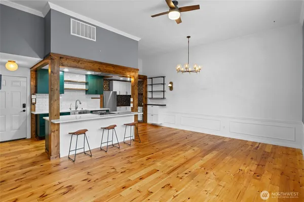 a open kitchen with white cabinets and wooden floor