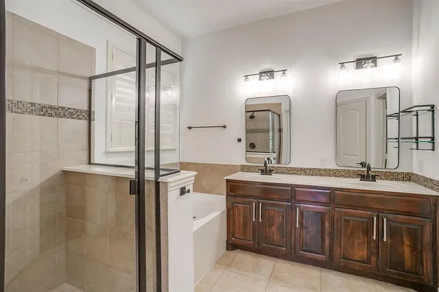 a bathroom with a granite countertop sink mirror bathtub and shower