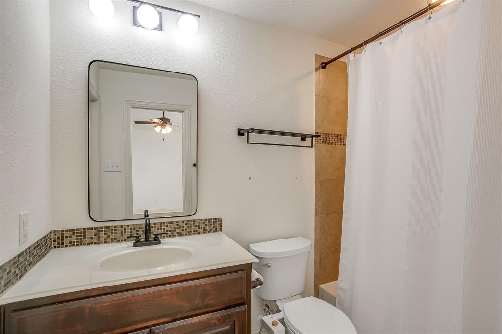3009 Montebello Drive Denton, TX 76210 - Photo 25 of 38 a bathroom with a granite countertop sink mirror vanity and toilet