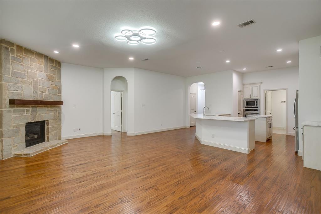 3009 Montebello Drive Denton, TX 76210 - Photo 8 of 38 a view of kitchen with kitchen island wooden floor center island and stainless steel appliances