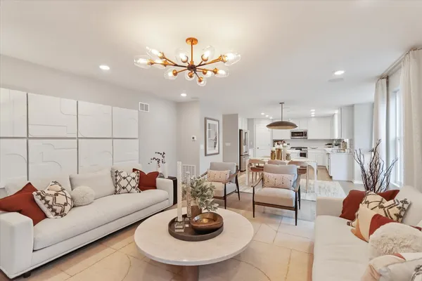 a living room with furniture kitchen and a chandelier