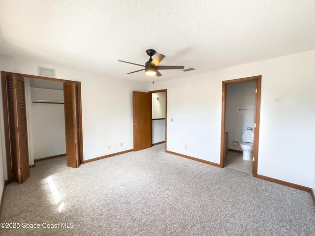 a view of an empty room with a ceiling fan