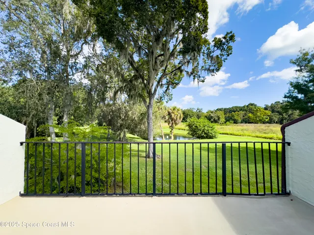 a view of a big room with windows and chandelier fan