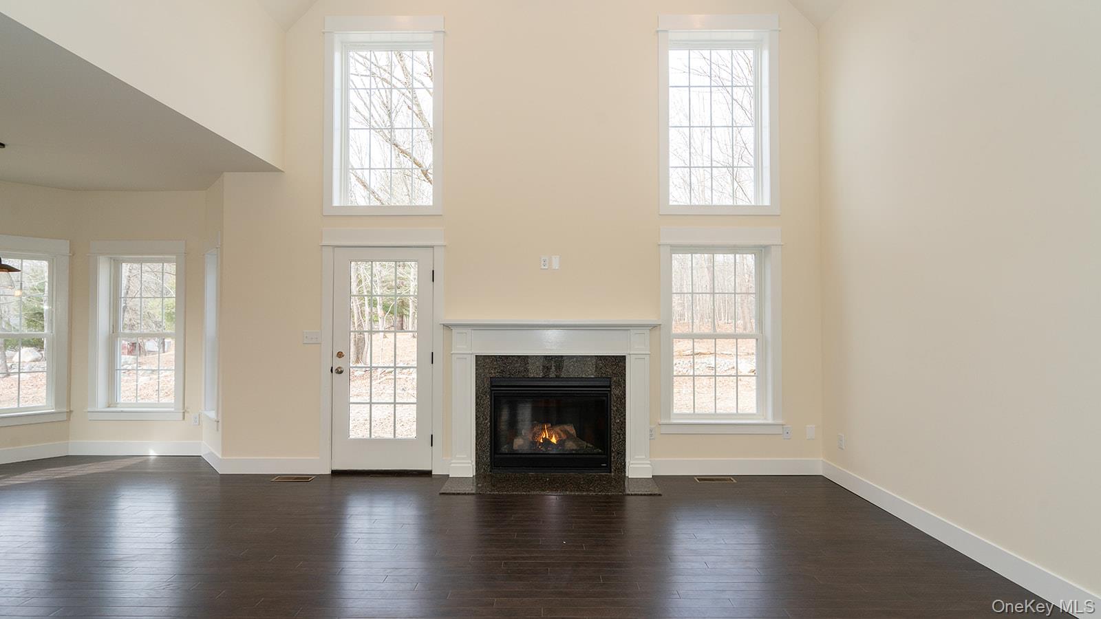 43 Malloy Road Wallkill, NY 12589 - Photo 11 of 50 Unfurnished living room featuring a high ceiling, dark wood-type flooring, and a fireplace