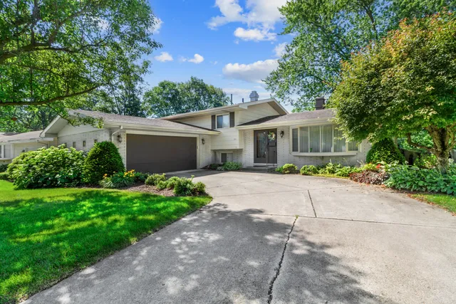 a front view of a house with a garden and plants
