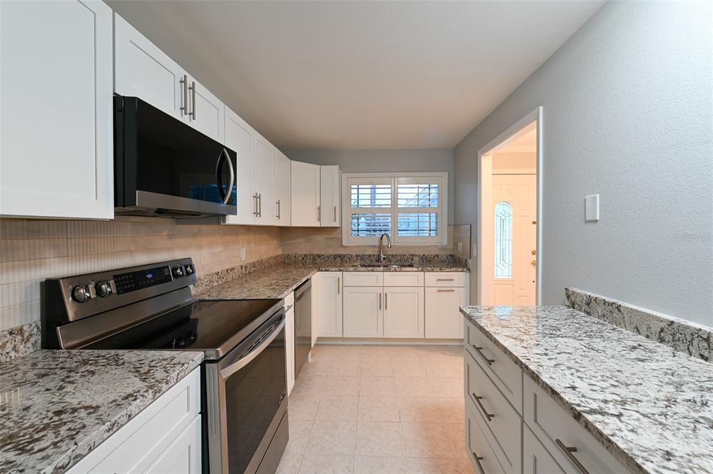 350 Boca Ciega Point Boulevard St. Petersburg, FL 33708 - Photo 11 of 25 a kitchen with granite countertop a sink and steel appliances
