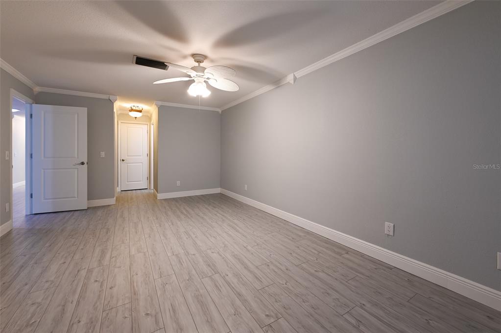 350 Boca Ciega Point Boulevard St. Petersburg, FL 33708 - Photo 12 of 25 a view of an empty room with wooden floor and a ceiling fan