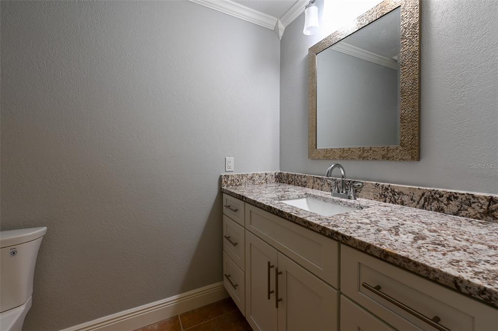 350 Boca Ciega Point Boulevard St. Petersburg, FL 33708 - Photo 14 of 32 a bathroom with a granite countertop sink and a mirror