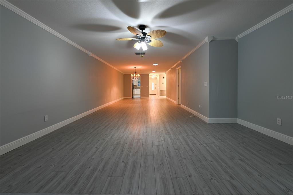 350 Boca Ciega Point Boulevard St. Petersburg, FL 33708 - Photo 5 of 25 a view of an empty room with wooden floor and a fan