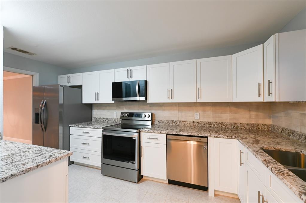 350 Boca Ciega Point Boulevard St. Petersburg, FL 33708 - Photo 9 of 25 a kitchen with white cabinets stainless steel appliances and sink