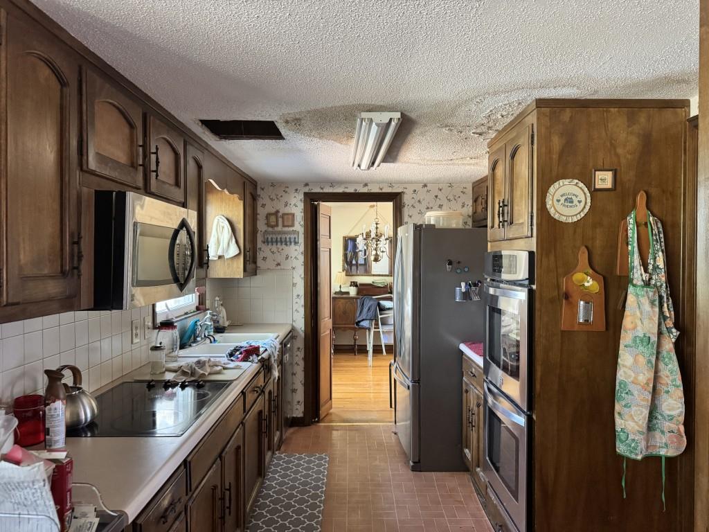 4703 Marc Court Southwest Lilburn, GA 30047 - Photo 12 of 57 a kitchen with stainless steel appliances granite countertop a refrigerator a stove and a sink