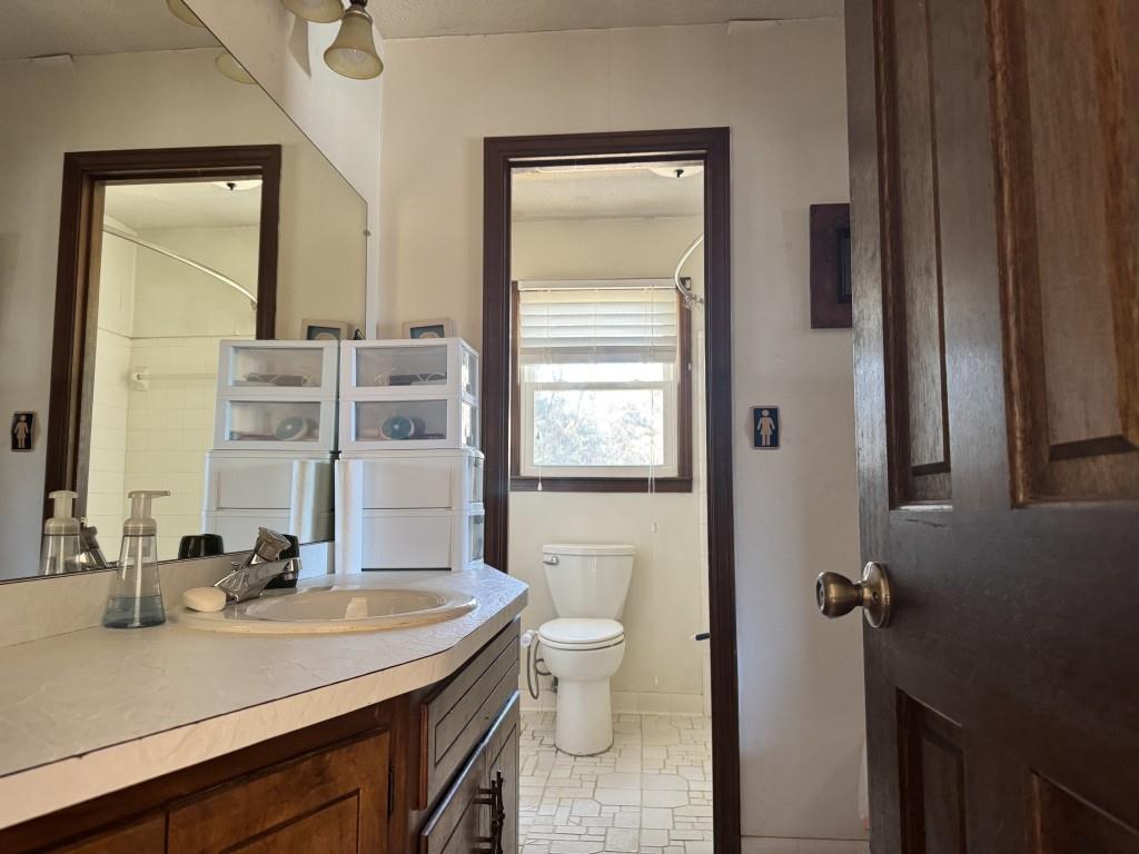 4703 Marc Court Southwest Lilburn, GA 30047 - Photo 36 of 57 a bathroom with a granite countertop sink a toilet and a mirror