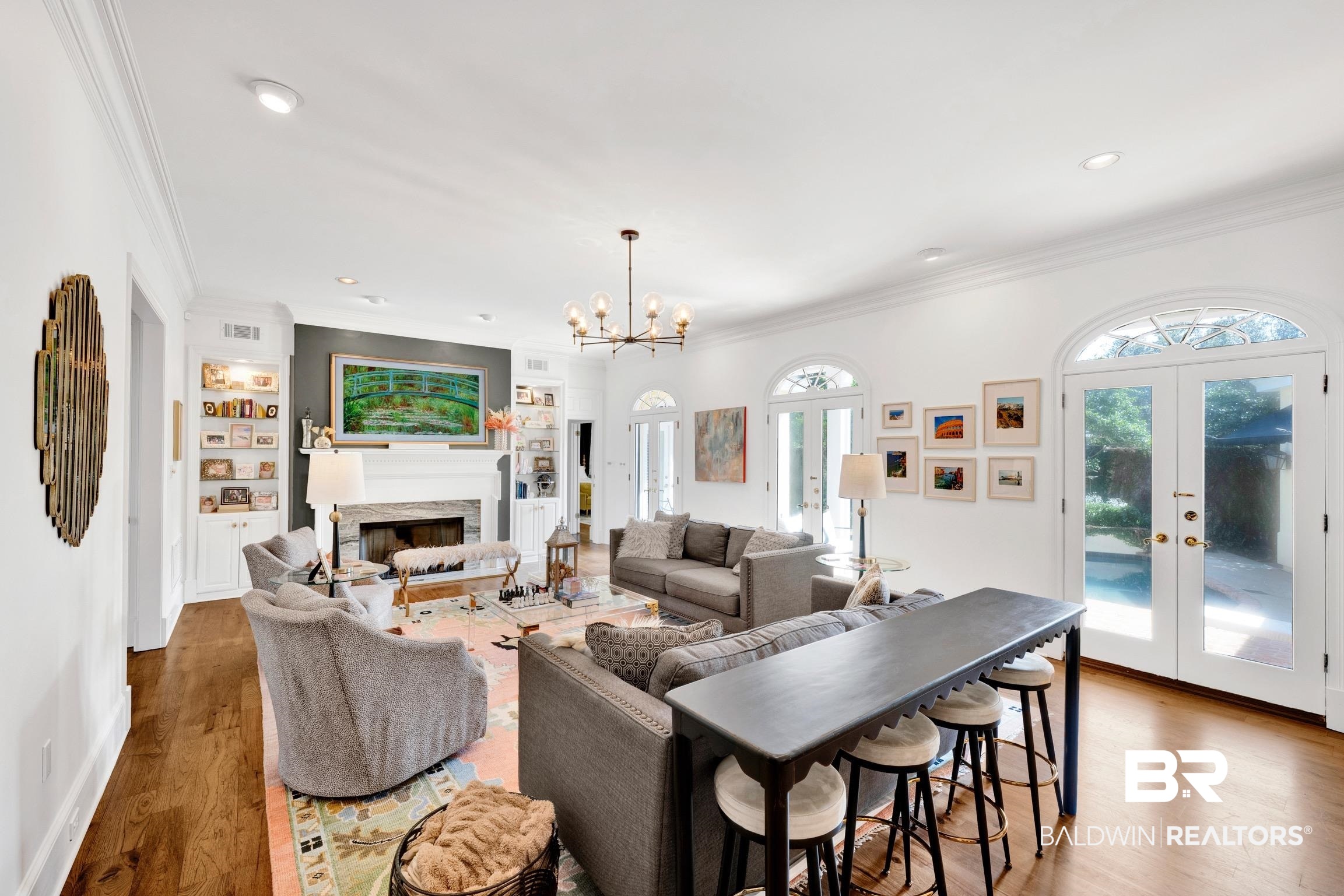 4 Savannah Court Mobile, AL 36608 - Photo 5 of 32 Living area featuring french doors, wood finished floors, crown molding, a premium fireplace, and hanging lights