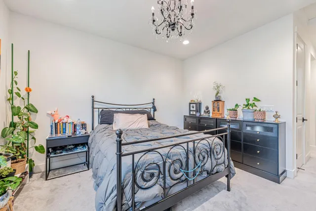 a bedroom with a bed table and a potted plant