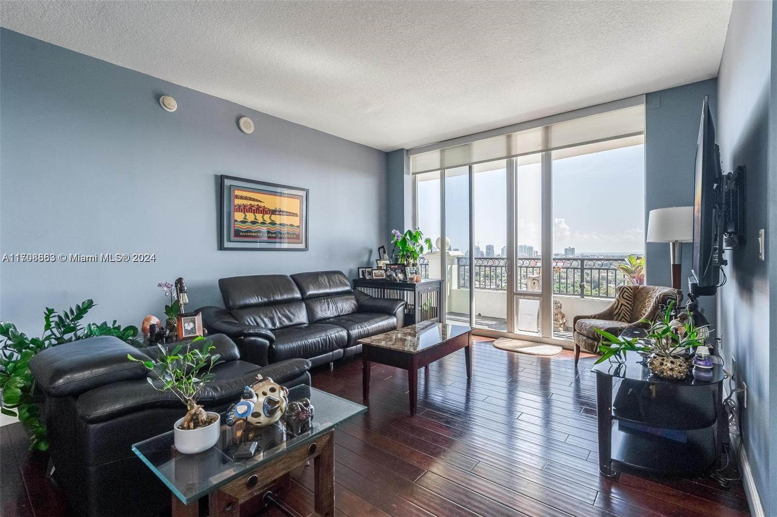 3232 Southwest 22nd Terrace, Unit 1903 Miami, FL 33145 - Photo 5 of 30 a living room with furniture potted plant floor to ceiling window and wooden floor