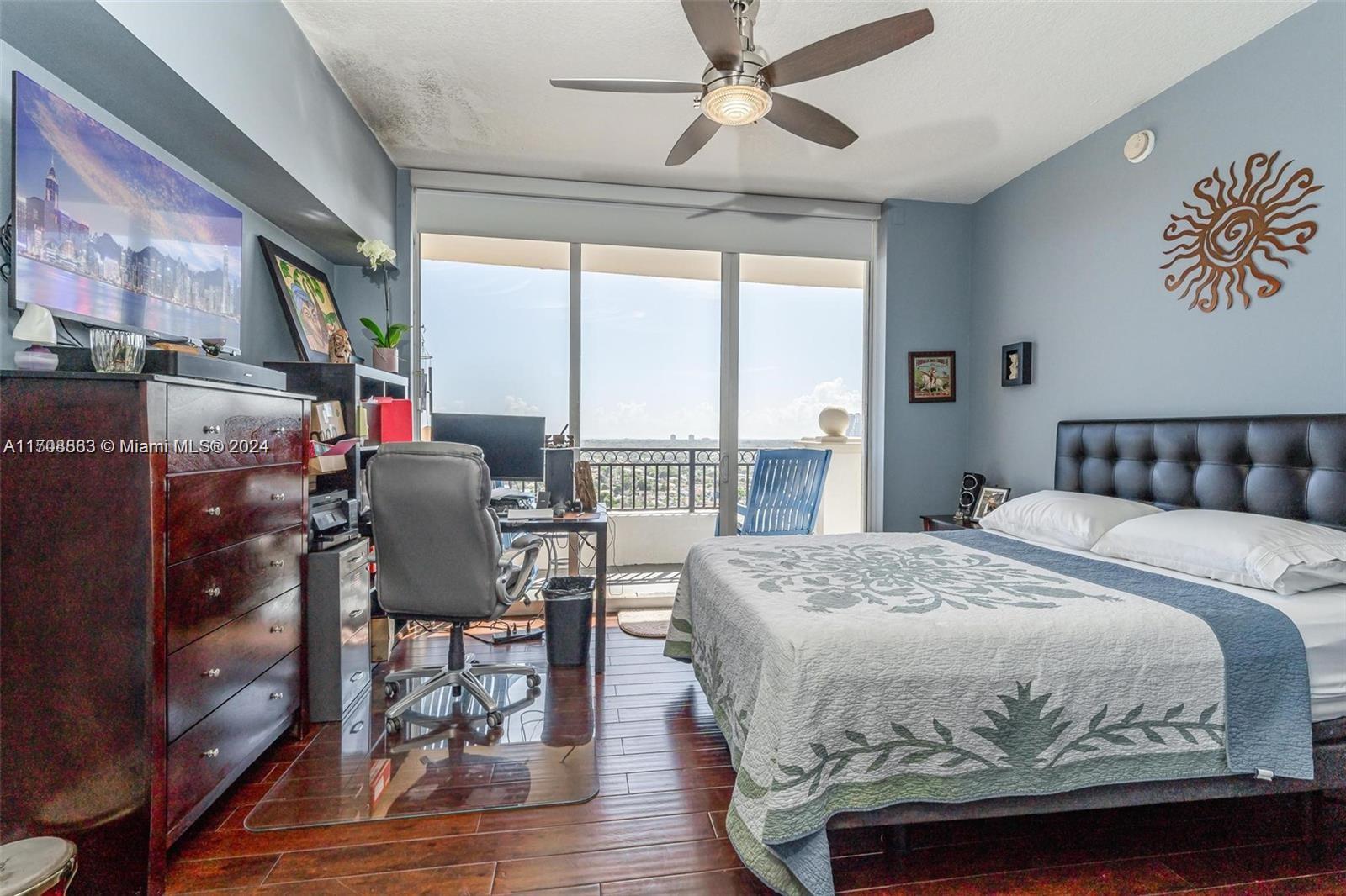 3232 Southwest 22nd Terrace, Unit 1903 Miami, FL 33145 - Photo 9 of 30 a bedroom with a bed and wooden floor