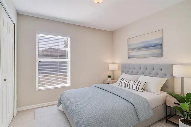 a bedroom with a bed and a painting on the wall