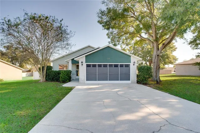a front view of a house with yard and tree