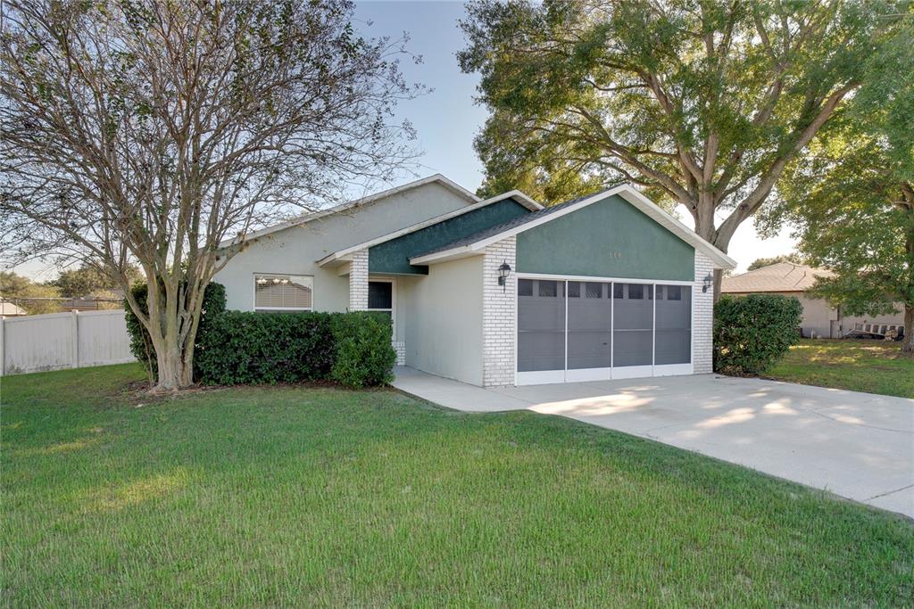 108 Brittany Road Mascotte, FL 34753 - Photo 21 of 23 a big white house with a yard and large trees
