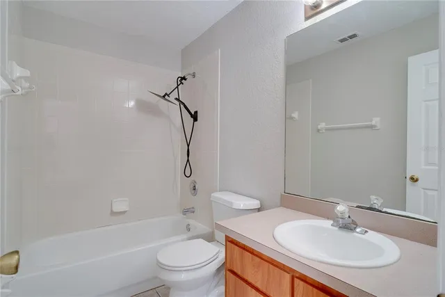a bathroom with a sink toilet tub vanity and shower