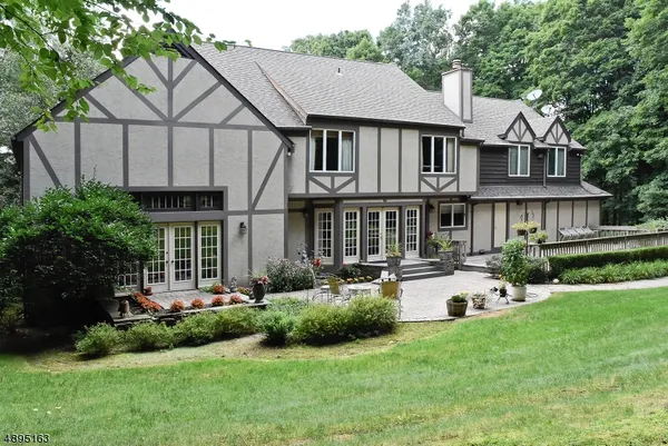 a front view of a house with a yard garden and outdoor seating
