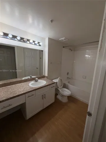 a bathroom with a granite countertop sink mirror and toilet