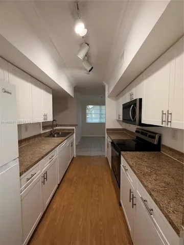 a large kitchen with a stove and a sink