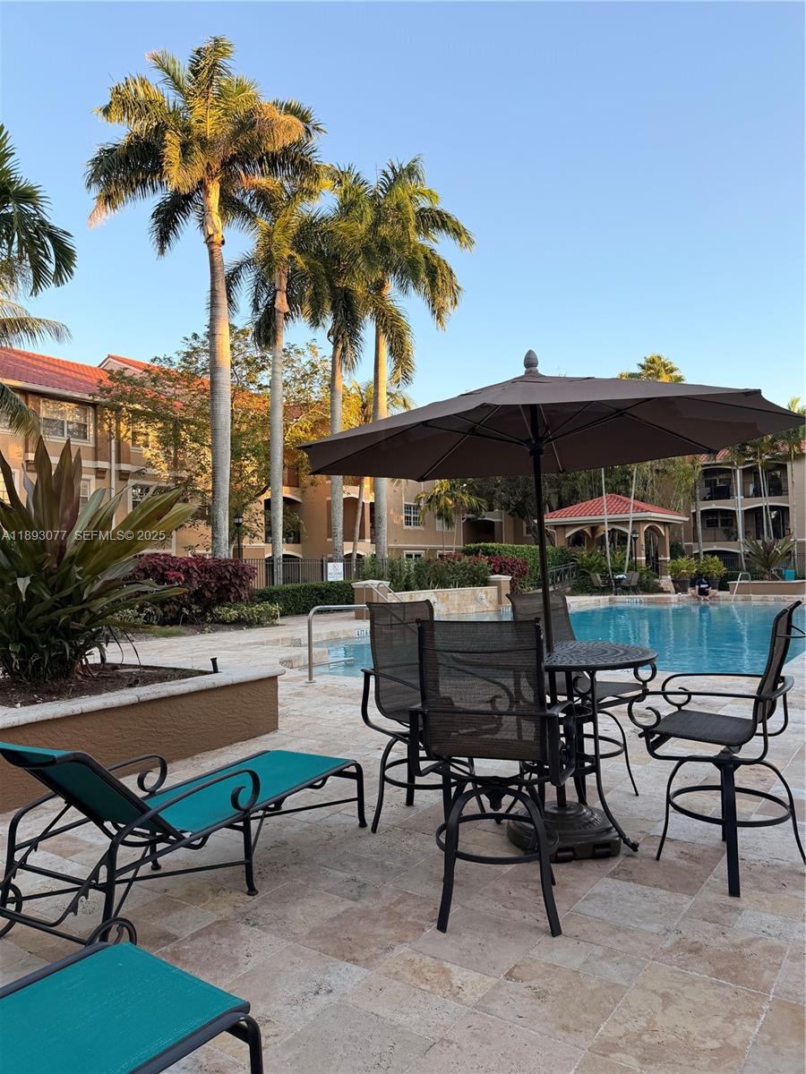 151 Southwest 117th Avenue, Unit 9108 Pembroke Pines, FL 33025 - Photo 6 of 12 a view of a chairs and table in patio