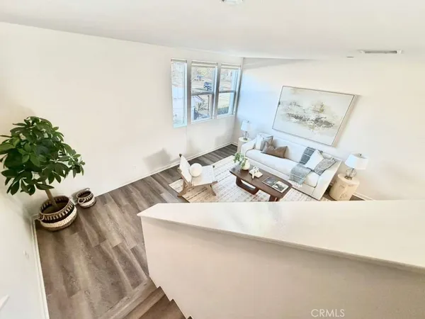a open kitchen with stainless steel appliances a stove top oven a sink dishwasher and a refrigerator with wooden floor