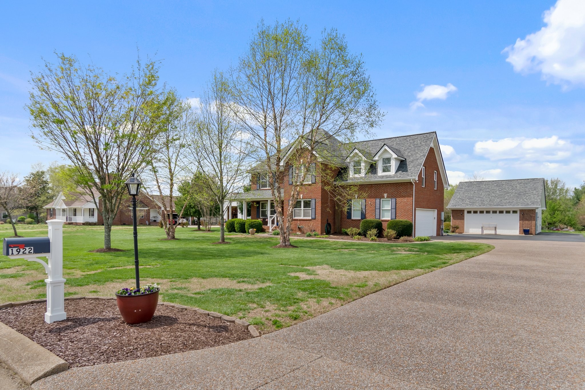 a front view of a house with a yard and tree s