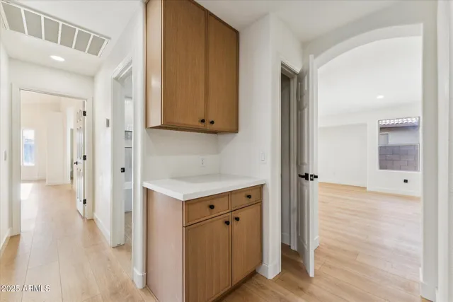 a view of a hallway with wooden floor and closet area