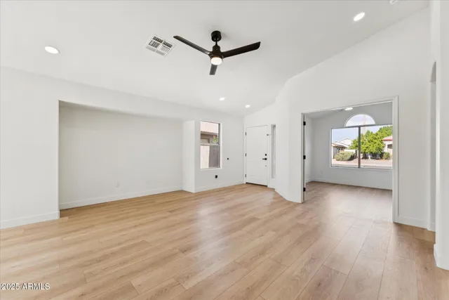 a view of an empty room with a window and wooden floor